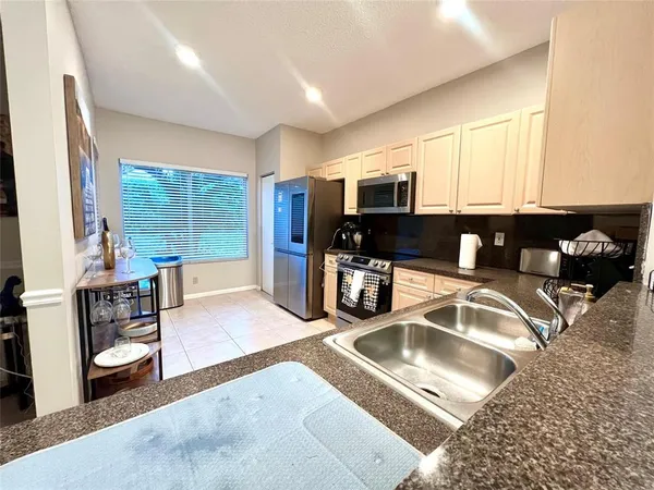 a kitchen with stainless steel appliances granite countertop a sink stove and cabinets