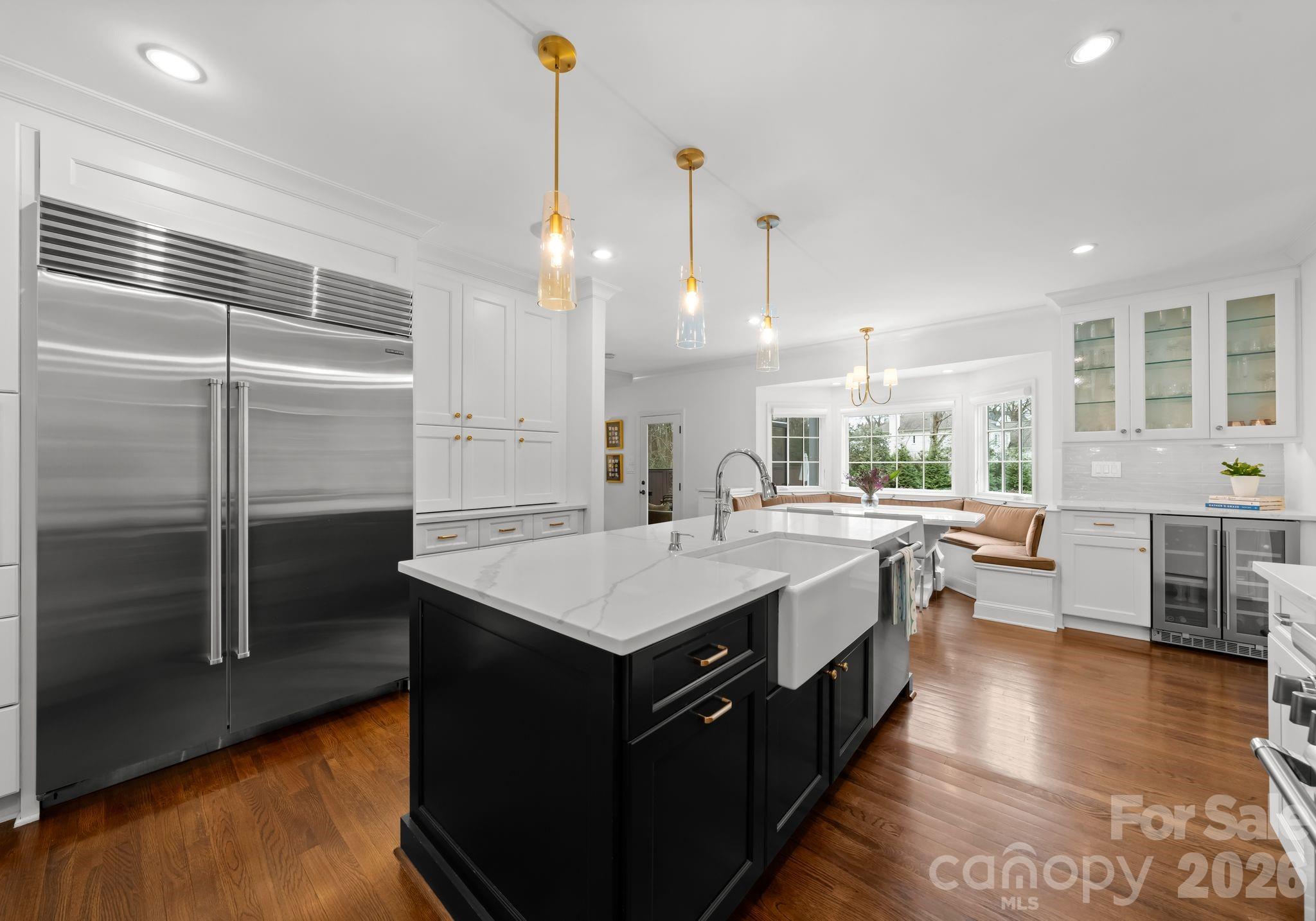 3800 River Ridge Road Charlotte, NC 28226 - Photo 11 of 48 a large kitchen with kitchen island a stove a sink a refrigerator and a dining table with wooden floor