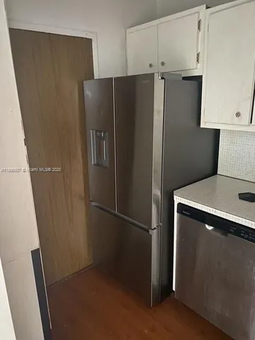 a metallic refrigerator freezer sitting in a kitchen