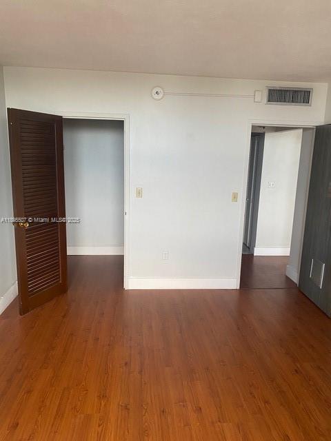 2899 Collins Avenue, Unit 1746 Miami Beach, FL 33140 - Photo 9 of 12 a view of an empty room with wooden floor and a window