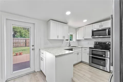 a kitchen with stainless steel appliances stove microwave and cabinets