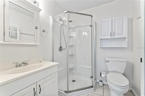 a bathroom with a shower sink mirror and toilet