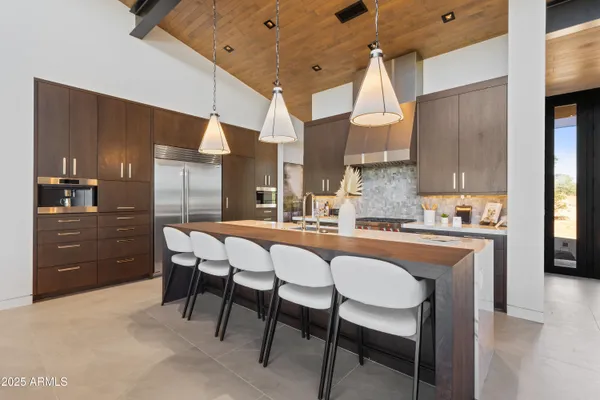 a dining area with a table chairs sink and cabinets