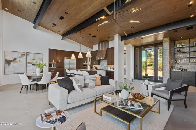 a living room with furniture kitchen view and a large window