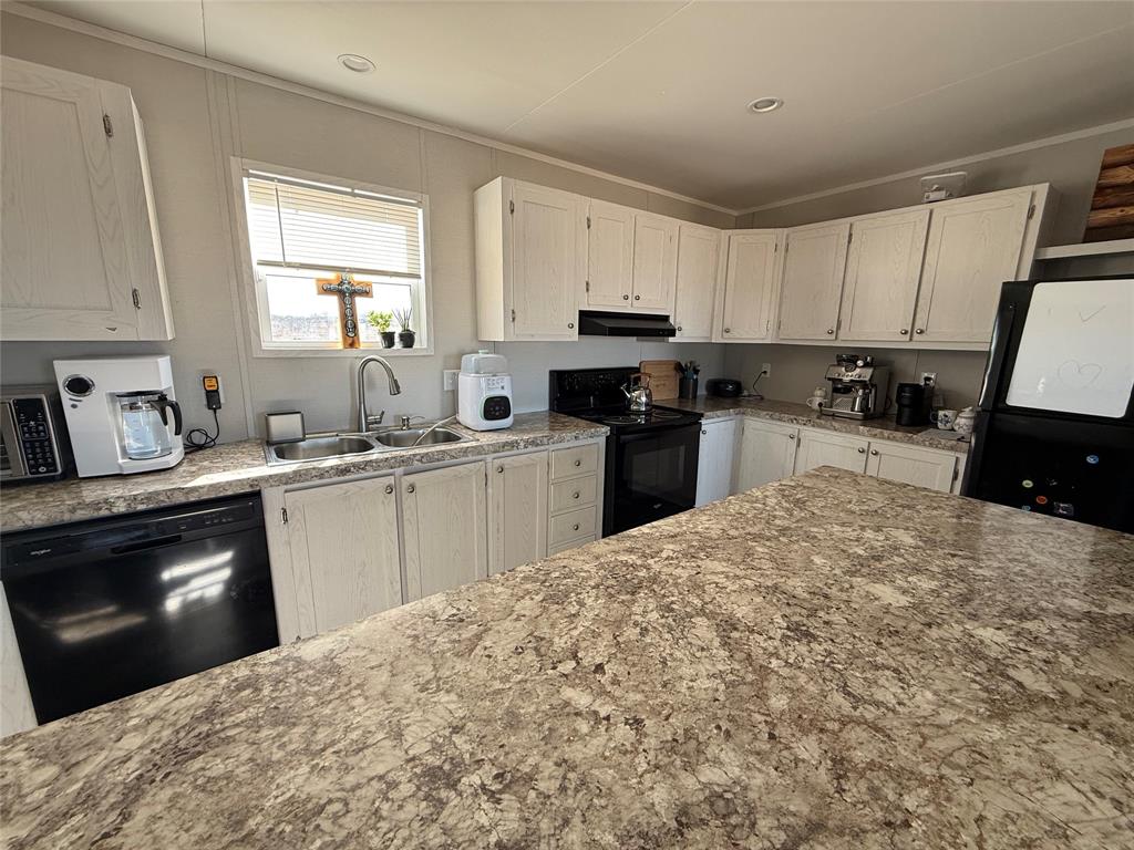 126 Common Way Boyd, TX 76023 - Photo 3 of 14 a kitchen with a sink a stove top oven and cabinetry