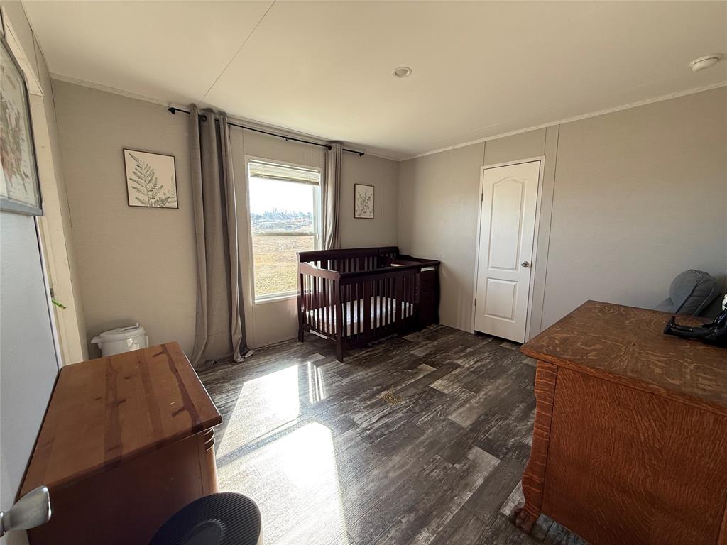 126 Common Way Boyd, TX 76023 - Photo 6 of 14 a bedroom with a bed and wooden floor