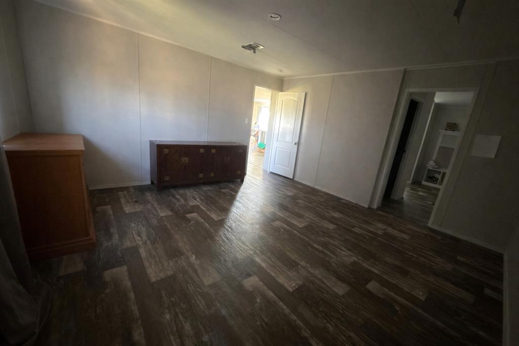 126 Common Way Boyd, TX 76023 - Photo 7 of 14 a view of an empty room with wooden floor and a window