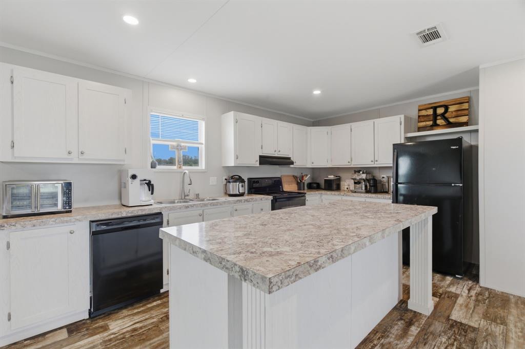 126 Common Way Boyd, TX 76023 - Photo 8 of 19 a kitchen with granite countertop a sink stove and refrigerator