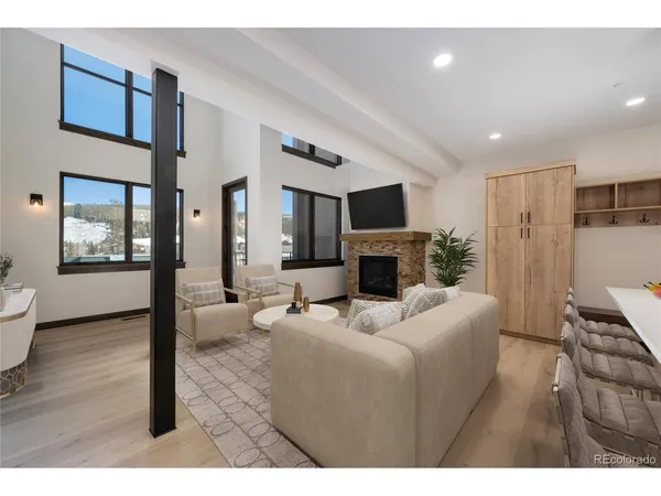 a living room with furniture a fireplace and a potted plant
