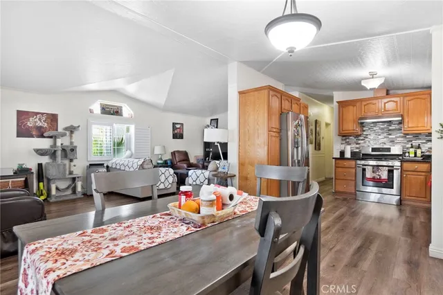 a living room with furniture kitchen view and a large window