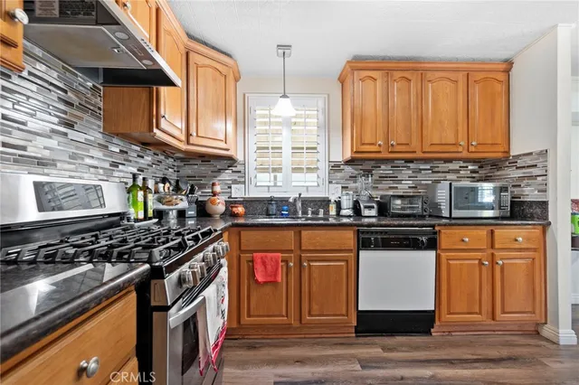 a kitchen with stainless steel appliances granite countertop a stove a sink and a microwave