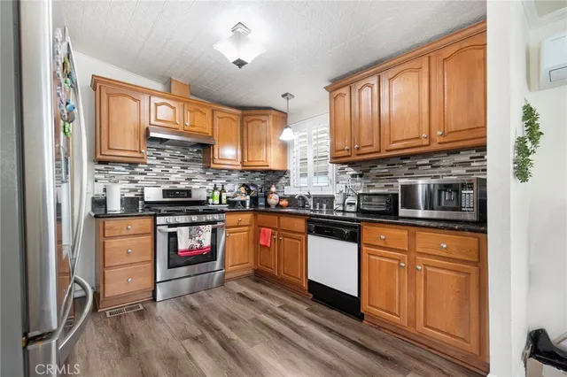 a kitchen with stainless steel appliances granite countertop a stove sink and cabinets