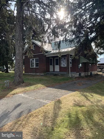 a front view of a house with a yard and trees