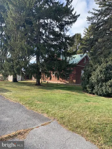 a view of a trees in front of a house with a yard