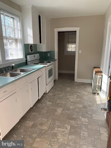 a kitchen with granite countertop a sink and white cabinets