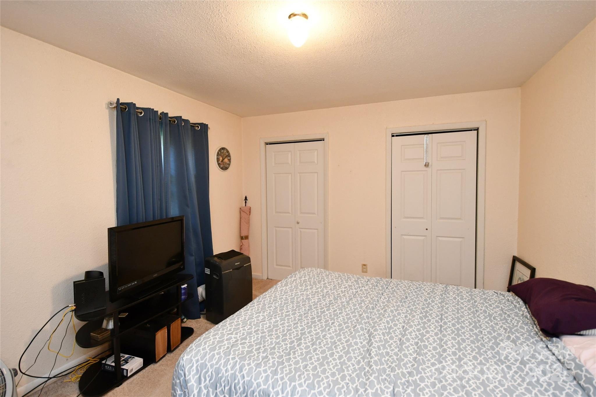 1227 Georges Fork Road Burnsville, NC 28714 - Photo 19 of 36 a bedroom with a bed and a flat screen tv