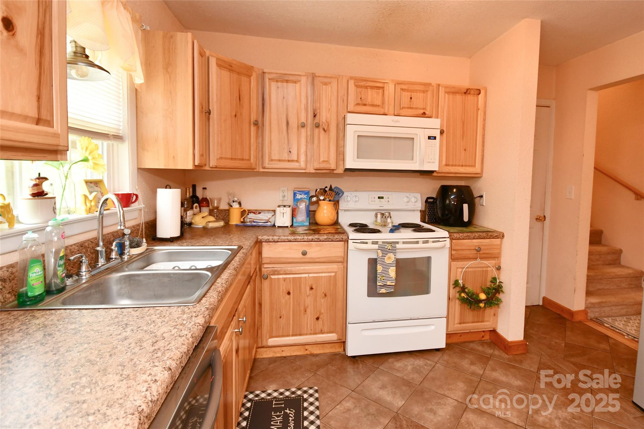 1227 Georges Fork Road Burnsville, NC 28714 - Photo 6 of 36 a kitchen with stainless steel appliances granite countertop a sink a stove and a microwave oven with white cabinets