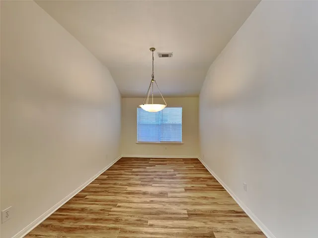a view of a room with a ceiling fan and wooden floor
