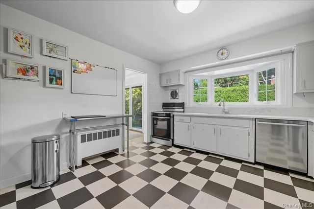 a kitchen with a checkered floor and white cabinets