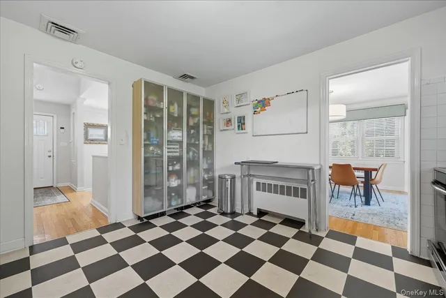 a view of a black and white checkered floor with a rug