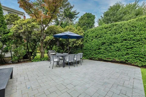 a view of a table and chairs under an umbrella in backyard