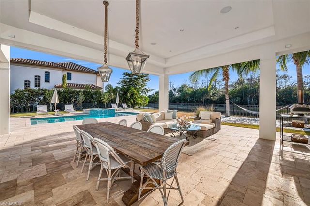 a view of a patio with a table chairs and a floor to ceiling window
