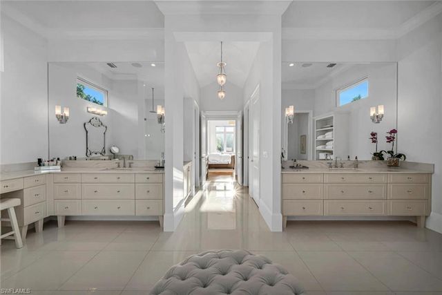 a bathroom with double vanity sink and mirror with bathtub