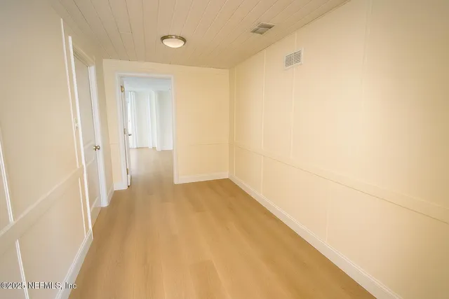 a view of a big room with wooden floor and brick walls