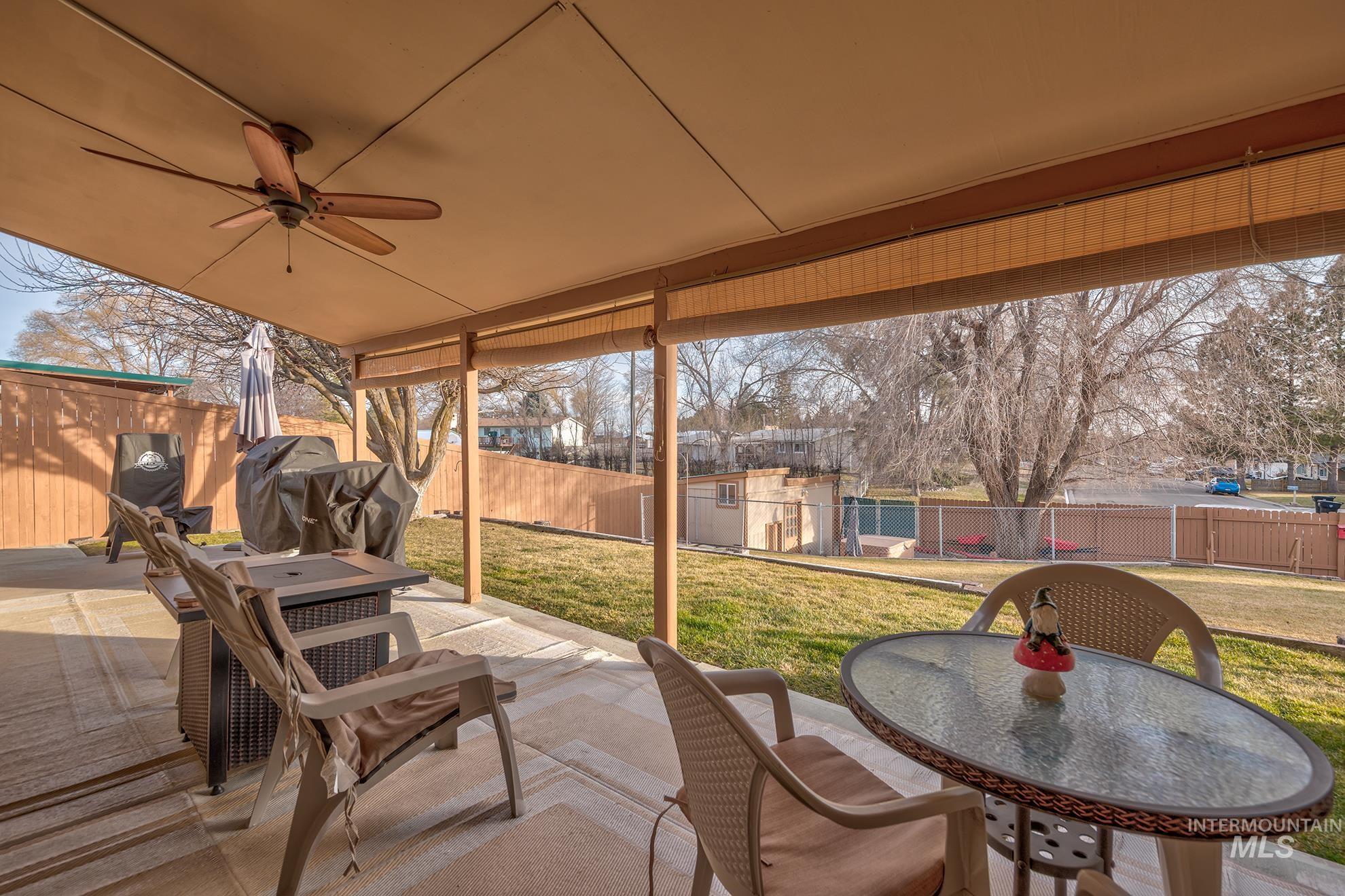 611 West Indianhead Road Weiser, ID 83672 - Photo 24 of 34 Fenced backyard featuring a patio, outdoor dining area, a ceiling fan, and a shed