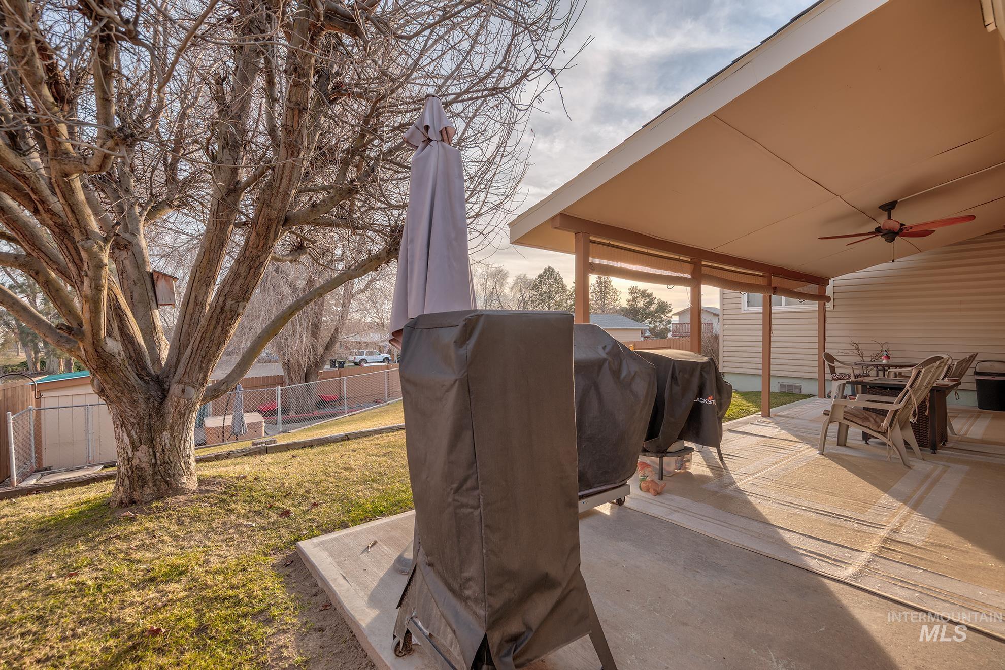 611 West Indianhead Road Weiser, ID 83672 - Photo 25 of 34 Fenced backyard with a ceiling fan, grilling area, a patio, and outdoor dining space