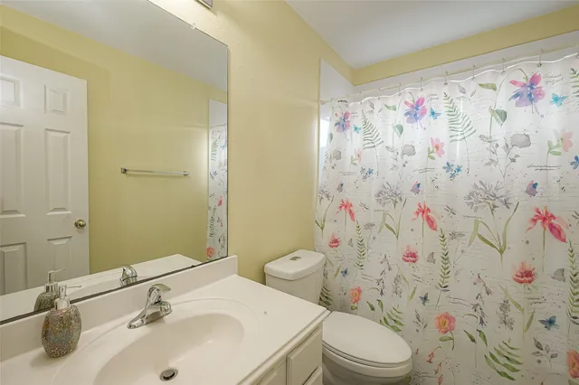 a bathroom with a sink and mirror with toilet