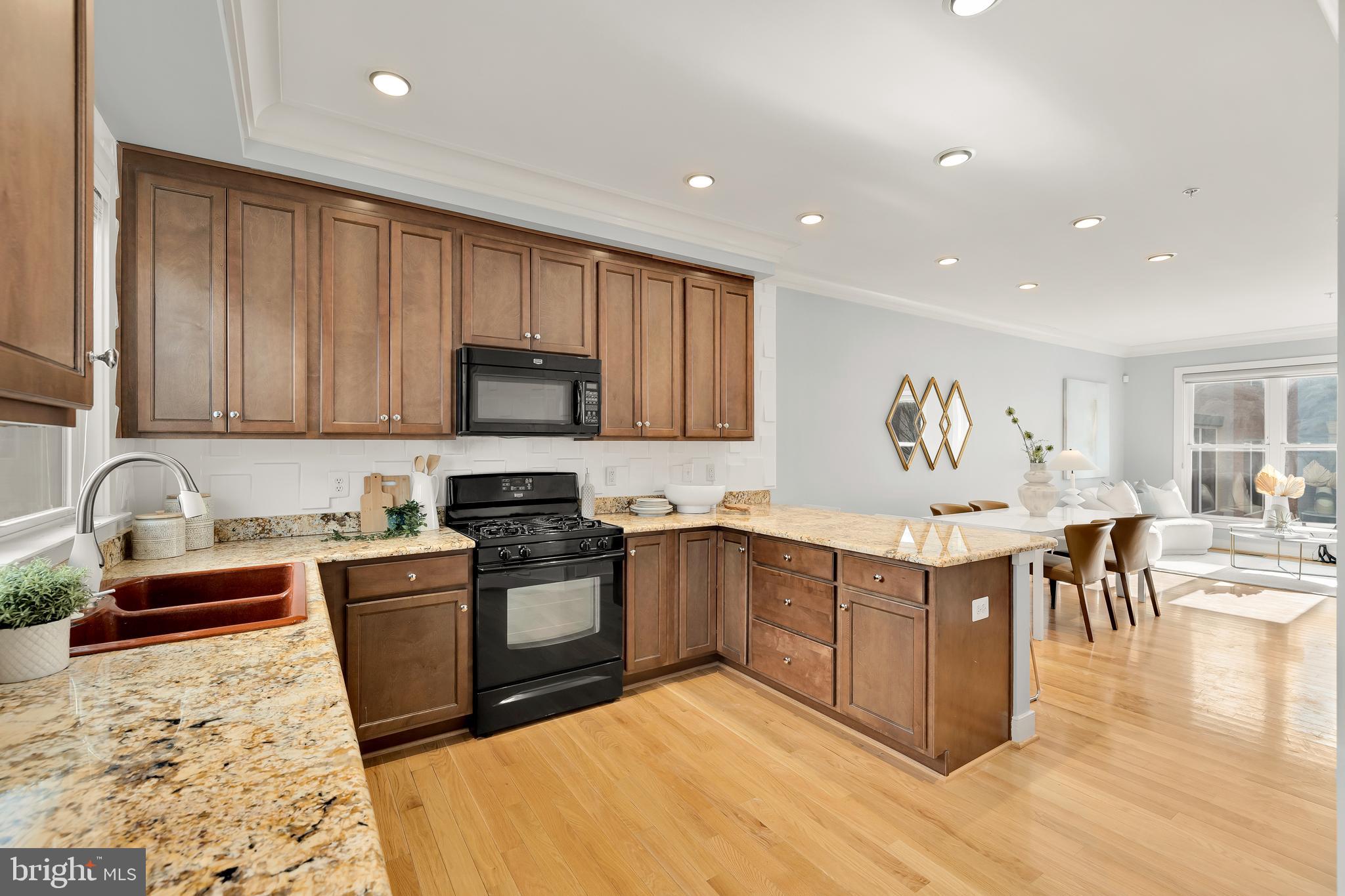 908 3rd Place Southeast Washington, DC 20003 - Photo 7 of 26 a kitchen with stainless steel appliances granite countertop a stove top oven a sink dishwasher a dining table and chairs with wooden floors