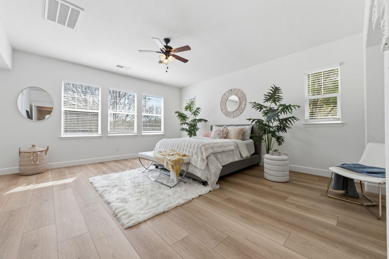 698 West Rico Way Tracy, CA 95391 - Photo 27 of 48 a bedroom with a large bed wooden floor and windows
