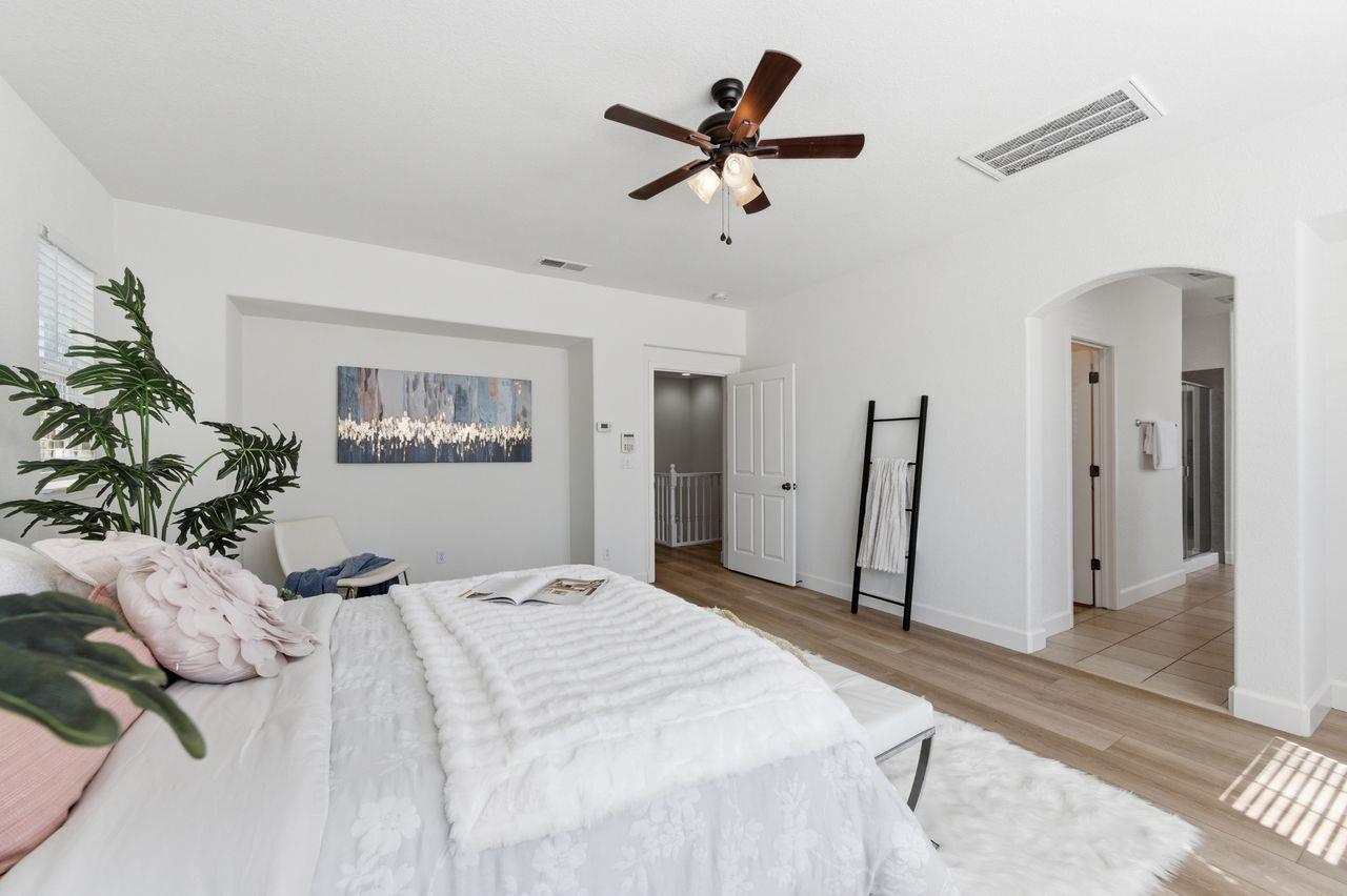 698 West Rico Way Tracy, CA 95391 - Photo 28 of 48 a bedroom with a large bed and a chandelier