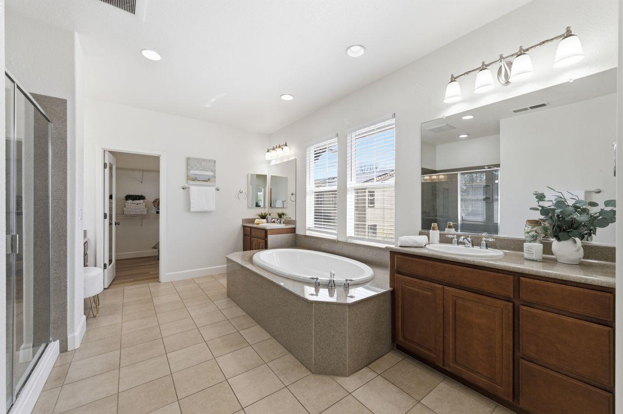 698 West Rico Way Tracy, CA 95391 - Photo 29 of 48 a bathroom with a granite countertop bathtub sink and mirror