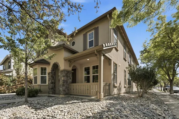 a front view of a house with a tree