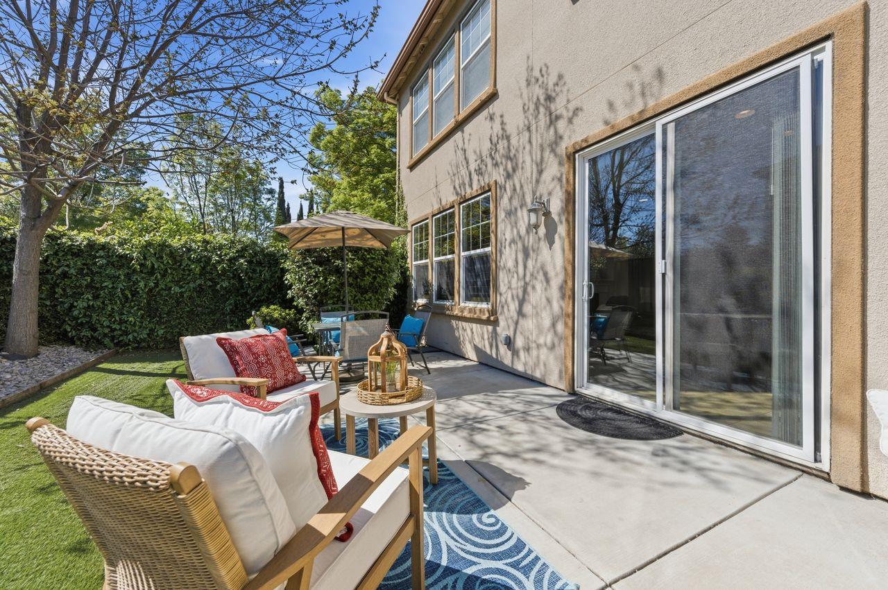 698 West Rico Way Tracy, CA 95391 - Photo 46 of 48 a view of a patio with a dining table and chairs next to a yard