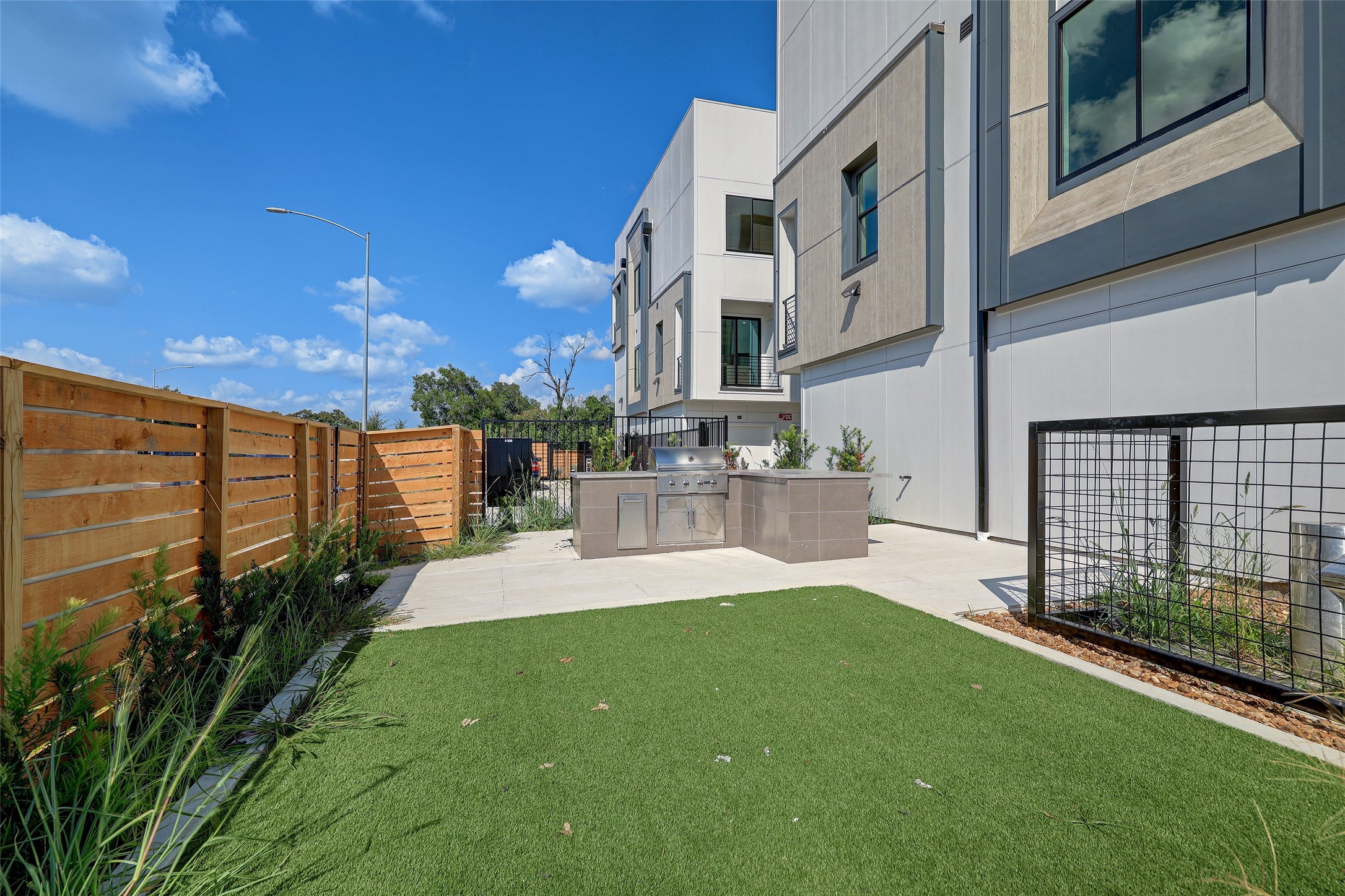 4932 Old Spanish Trail, Unit D301 Houston, TX 77021 - Photo 26 of 29 a view of a patio with table and chairs with wooden floor and fence