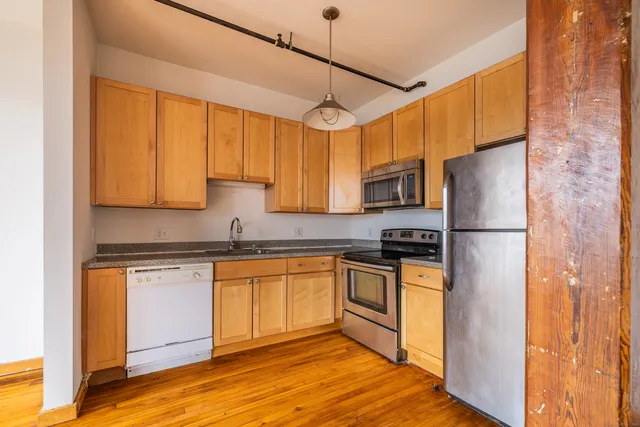 a kitchen with stainless steel appliances granite countertop a refrigerator and a stove top oven