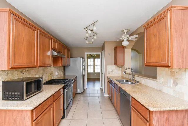 a spacious kitchen with stainless steel appliances granite countertop a sink stove and cabinets