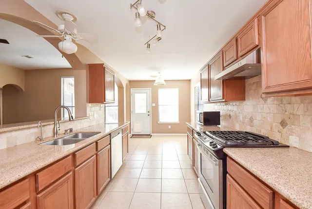 a kitchen with stainless steel appliances kitchen island granite countertop a sink and cabinets