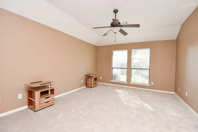a view of a room with a ceiling fan and a window