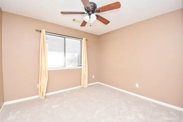 an empty room with closet and windows