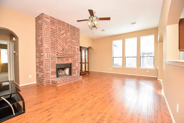 a view of an empty room with a fireplace and a window