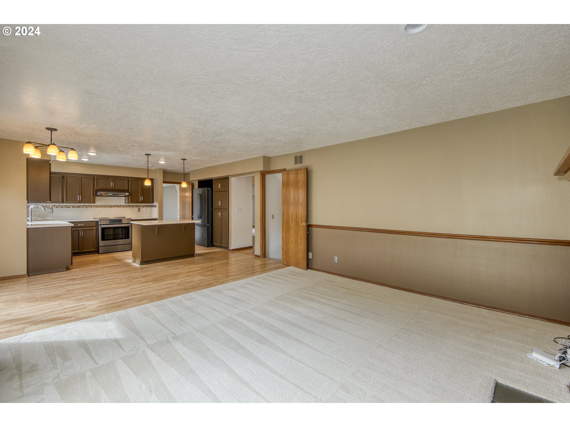612 Southeast Lovrien Place Gresham, OR 97080 - Photo 15 of 48 a view of empty room with kitchen appliances and wooden floor