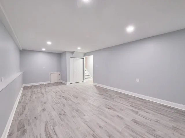a view of empty room with wooden floor