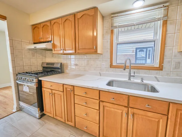 a kitchen with stainless steel appliances granite countertop a sink and cabinets with wooden floor