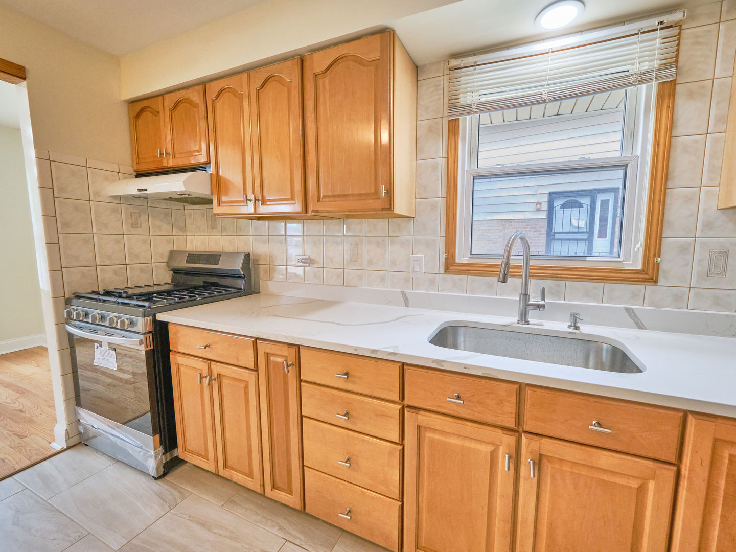 18207 Ravisloe Terrace Country Club Hills, IL 60478 - Photo 6 of 24 a kitchen with stainless steel appliances granite countertop a sink and cabinets with wooden floor