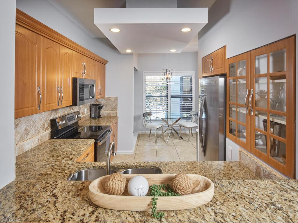 324 La Peninsula Boulevard, Unit 324 Naples, FL 34113 - Photo 9 of 35 a view of a living room and a chandelier