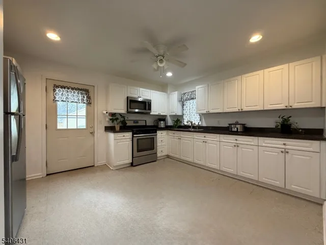 a view of a kitchen with a refrigerator and a stove top oven
